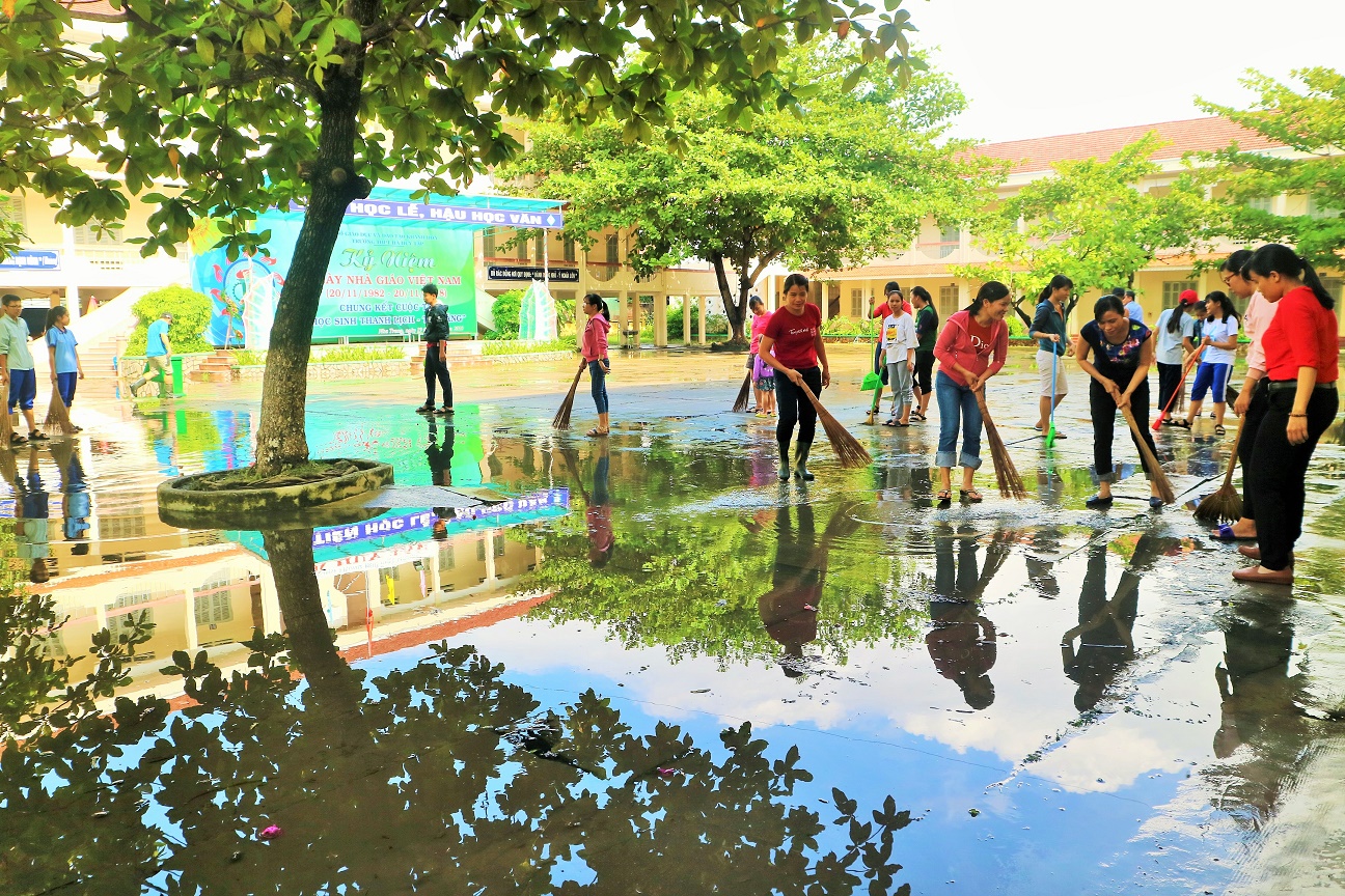 Giáo viên, học sinh Trường THPT Hà Huy Tập (Nha Trang) dọn dẹp sân trường sau trận mưa lớn tháng 11-2018. 