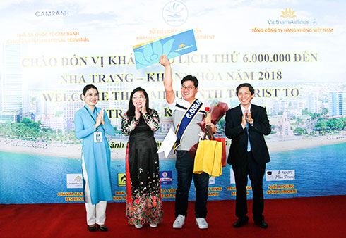 Lãnh đạo Sở Du lịch và đại diện Vietnam Airlines tặng quà cho  vị khách thứ 6 triệu là ông Lee Sang Soo - người Hàn Quốc. Ả