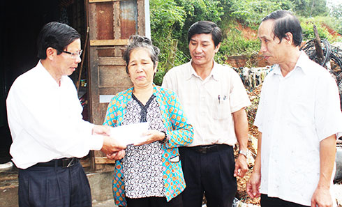 Ông Trần Ngọc Thanh - Chủ tịch UBMTTQ Việt Nam tỉnh trao hỗ trợ  cho các gia đình bị thiệt hại do mưa lũ. Ảnh: V.G