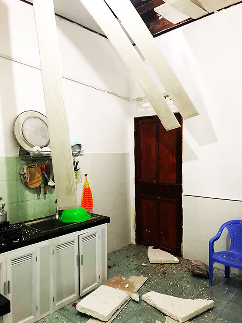 Bức tường sạt lở làm thủng mái tôn nhà dân