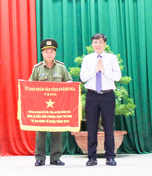 Đồng chí Lê Đức Vinh trao Cờ thi đua của UBND tỉnh  cho cán bộ, chiến sĩ Phòng An ninh đối nội.
