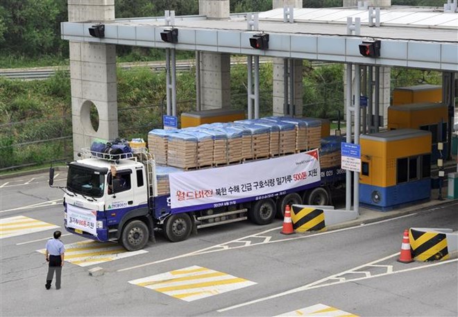 Xe tải Hàn Quốc chở bột mì viện trợ cho các nạn nhân lũ lụt tại Triều Tiên qua cửa khẩu thành phố biên giới Paju, phía bắc Seoul tháng 9/2011. (Ảnh: AFP/TTXVN)