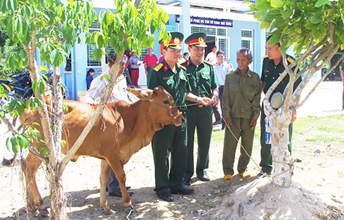 Lãnh đạo Ban Chỉ huy Quân sự huyện Khánh Vĩnh tặng bò giống cho các gia đình có hoàn cảnh khó khăn.