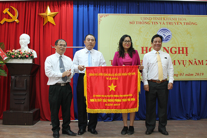 Đồng chí Hồ Văn Mừng (phải) thừa ủy quyền trao cờ thi đua của Thủ tướng Chính phủ cho lãnh đạo Sở TT-TT.  
