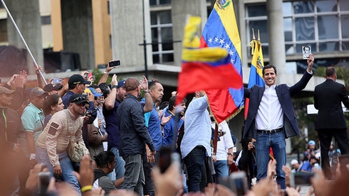 Ông Juan Guaido (người mặc vest, giơ ảnh) và những người ủng hộ. Ảnh: Getty.