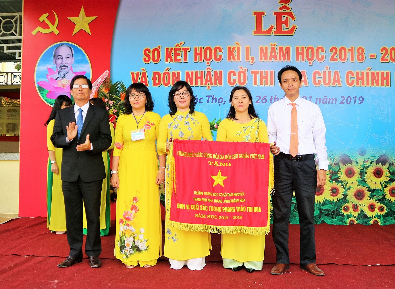 Ông Nguyễn Tấn Tuân trao cờ thi đua của Chính phủ cho nhà trường.