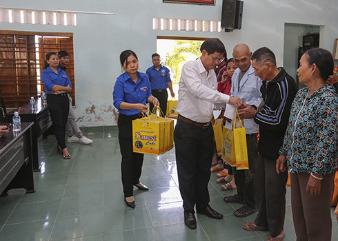 Đồng chí Nguyễn Tấn Tuân trao quà cho các gia đình.