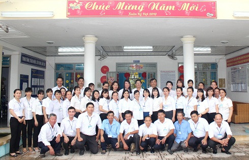 Ông Nguyễn Tấn Tuân chụp ảnh lưu niệm cùng cán bộ, nhân viên Trung tâm Bảo trợ xã hội Khánh Hòa.