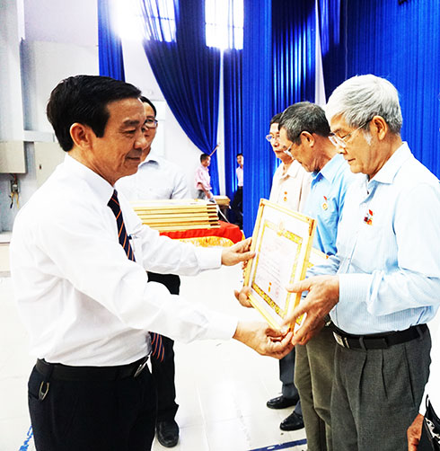 Đồng chí Nguyễn Thế Sinh - Phó Bí thư Thường trực  Thành ủy Nha Trang trao Huy hiệu Đảng cho các đảng viên.   