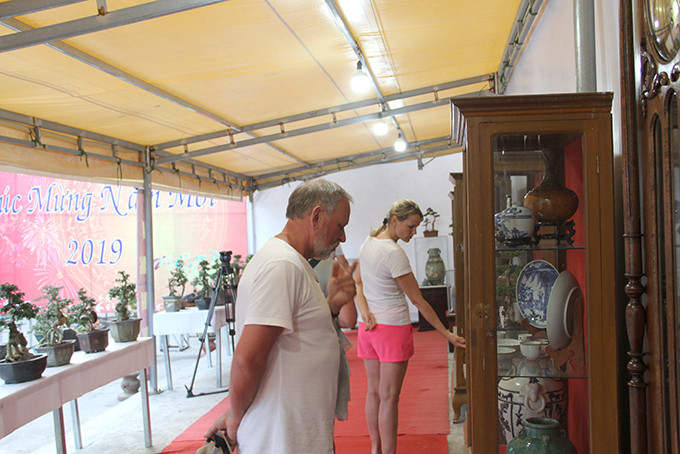 Du khách nước ngoài xem các cổ vật được giới thiệu tại triển lãm.