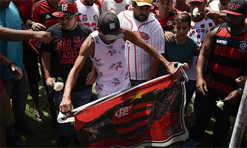 CĐV Flamengo và người thân của các nạn nhân tưởng niệm những tài năng trẻ xấu số. Ảnh: AP. 