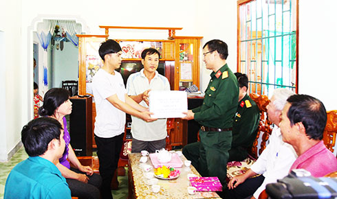 Cán bộ Ban Chỉ huy Quân sự huyện Cam Lâm tặng quà cho thanh niên  chuẩn bị lên đường nhập ngũ.