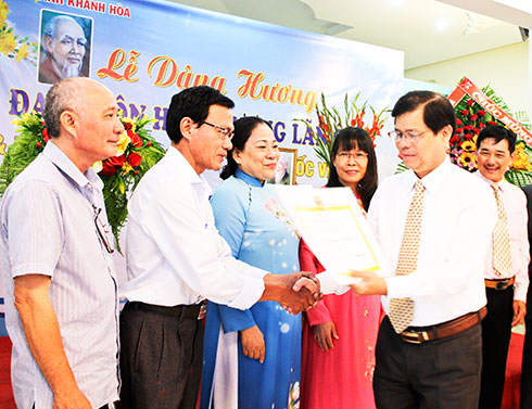 Đồng chí Nguyễn Tấn Tuân trao bằng khen của Trung ương Hội Đông y Việt Nam cho các tập thể.  