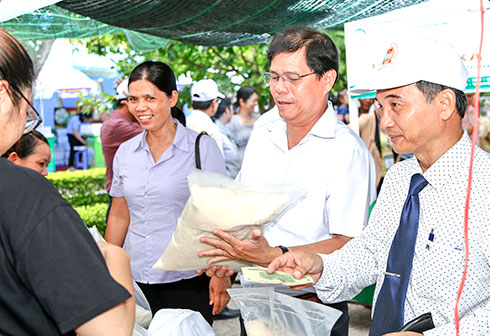 Đồng chí Nguyễn Tấn Tuân - Phó Bí thư Thường trực Tỉnh ủy, Chủ tịch HĐND tỉnh thăm gian hàng gạo Ngọc Quang tại Phiên chợ nông sản Khánh Hòa 2018.