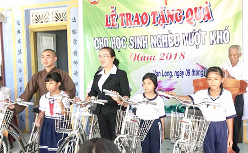 Đại diện chùa Khánh Long trao tặng phương tiện đến trường cho học sinh nghèo.