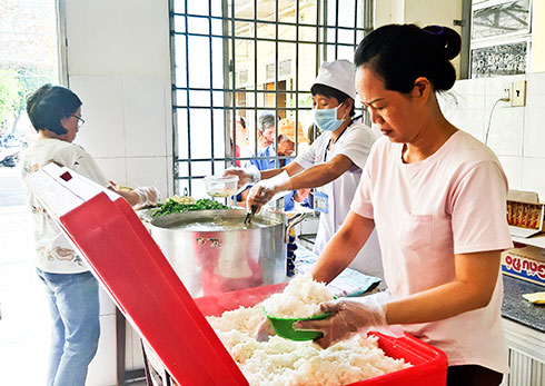 Các cô, các chị phát cơm từ thiện cho bệnh nhân nghèo.