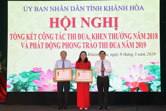 Ông Nguyễn Tấn Tuân thừa ủy quyền của Chủ tịch nước trao Huân chương Lao động hạng nhì cho hai cá nhân.