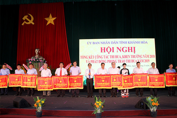 Ông Nguyễn Tấn Tuân trao cờ thi đua của UBND tỉnh cho các tập thể xuất sắc.