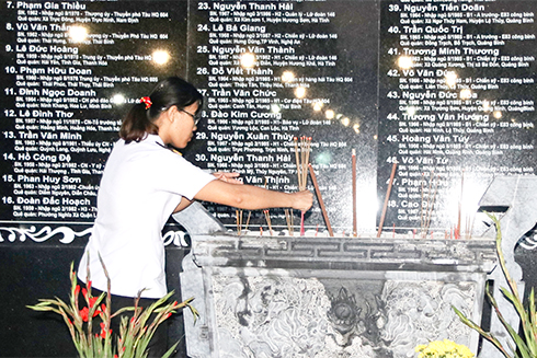 Chị Trần Thị Thủy thắp hương cho cha và các anh hùng, liệt sĩ tại Khu tưởng niệm chiến sĩ Gạc Ma. 
