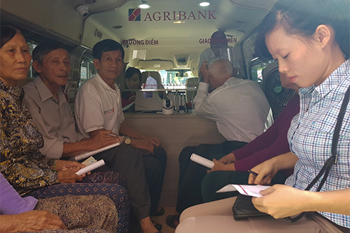 Local people doing banking transactions at mobile transaction spot of Agribank Khanh Hoa