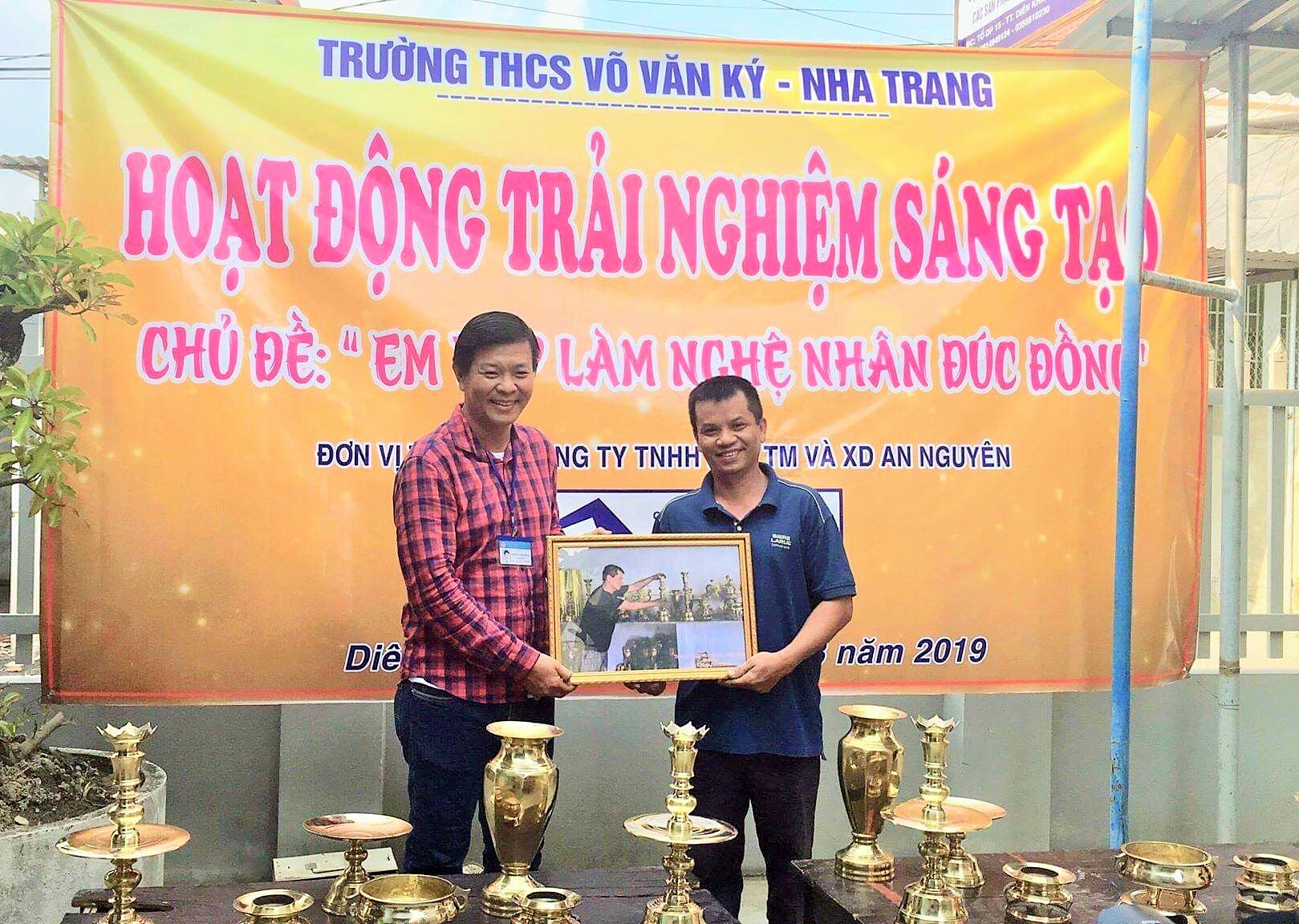 Trường THCS Võ Văn Ký tặng ảnh lưu niệm cho chủ cơ sở đúc đồng Minh Tiến. 