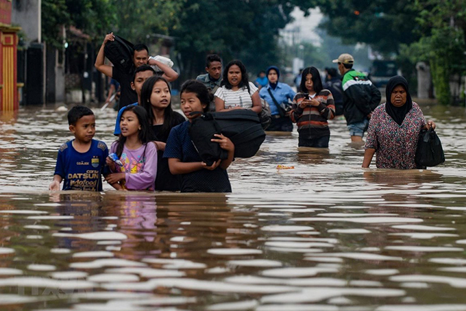 Sơ tán người dân khỏi khu vực ngập lụt sau mưa lớn tại làng Dayeuhkolot ở Bandung, Tây Java, Indonesia. (Nguồn: AFP/TTXVN)