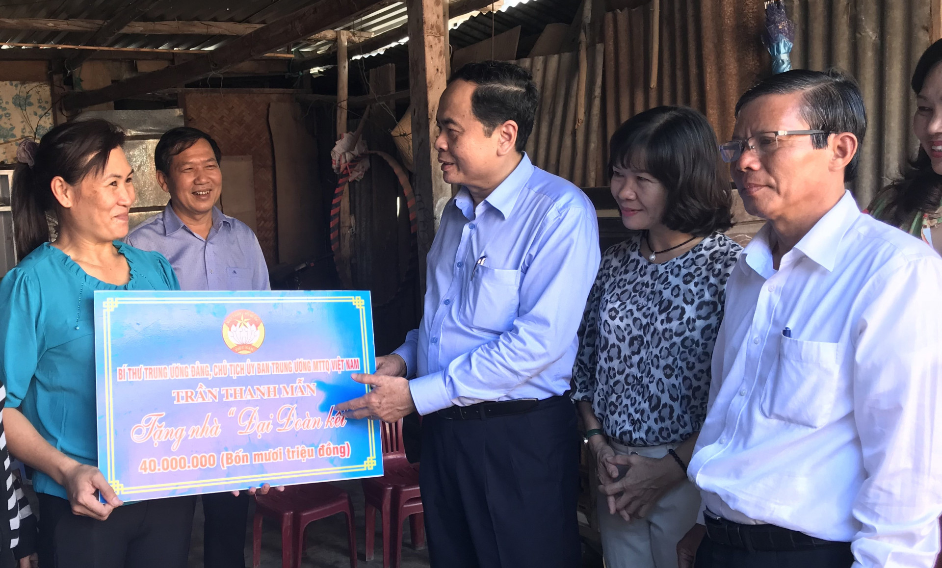 Đồng chí Trần Thanh Mẫn (bìa phải) trao tiền hỗ trợ xây nhà cho bà Nguyễn Thị Kim Chung