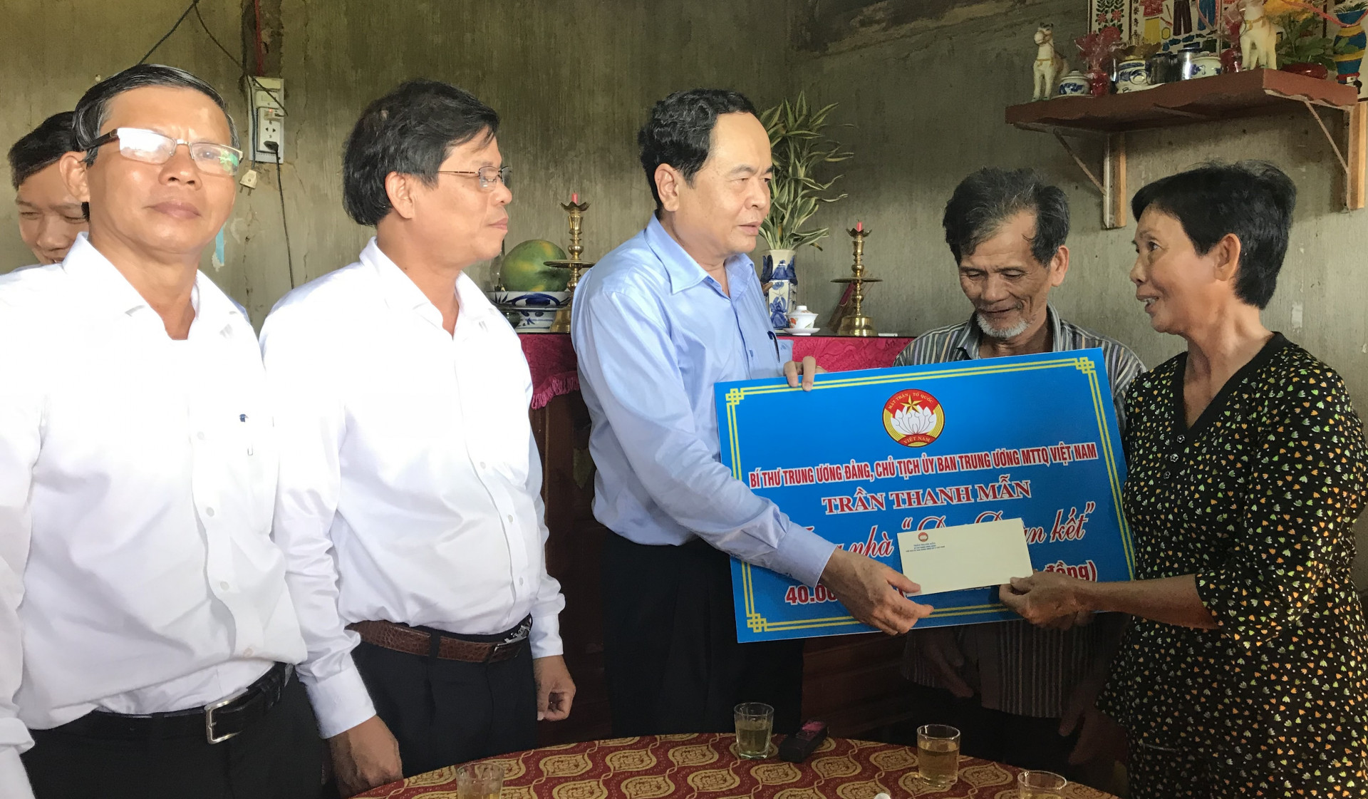 Đồng chí Trần Thanh Mẫn (đứng giữa) trao tiền hỗ trợ xây nhà cho gia đình bà Phạm Thị Dự