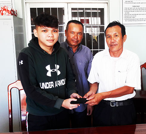 Em Nguyễn Nhật Thăng (trái) nhận lại ví từ Trung tá Nguyễn Thanh Măng.