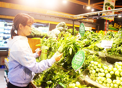 <p>Khách hàng lựa chọn rau được gói bằng lá chuối tại siêu thị.</p>