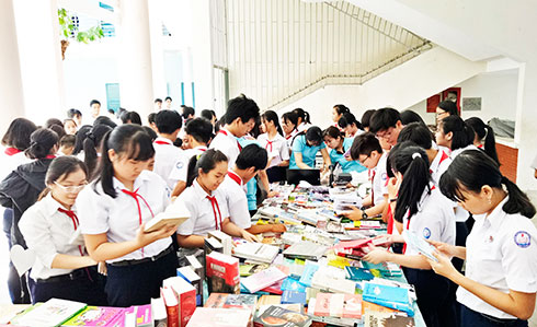 Pupils of Tran Nhat Duat Junior High School reading books at school book fair