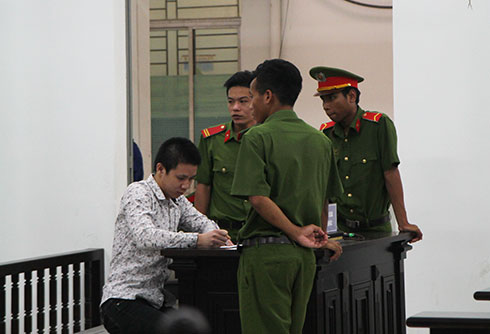 Bị cáo Nguyễn Văn Nghĩa viết giấy từ chối quyền nhờ người bào chữa ngay tại phiên tòa. 