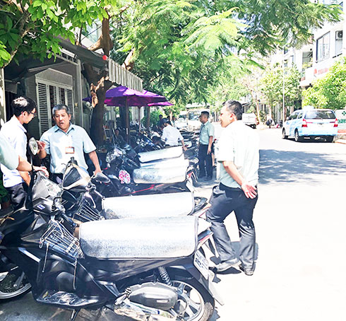 Lực lượng chức năng xử lý tình trạng xe lấn chiếm lòng đường tại một quán cà phê  trong Khu đô thị Vĩnh Điềm Trung.