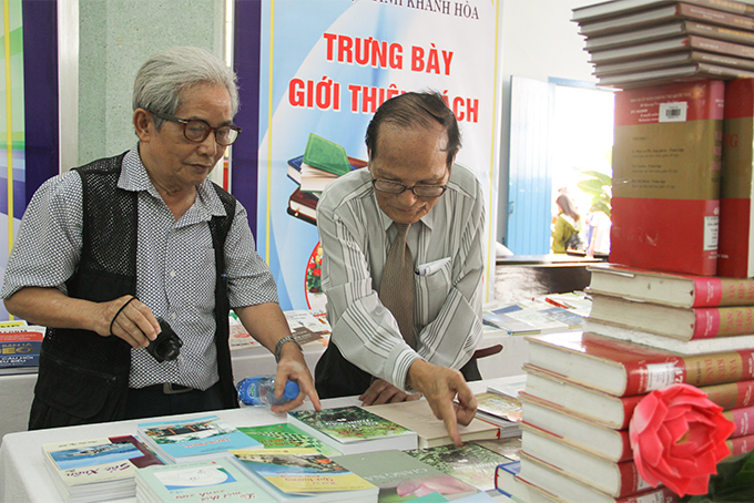Nhà thơ Giang Nam (bên phải) cũng đến xem sách được giới thiệu tại hội sách. 
