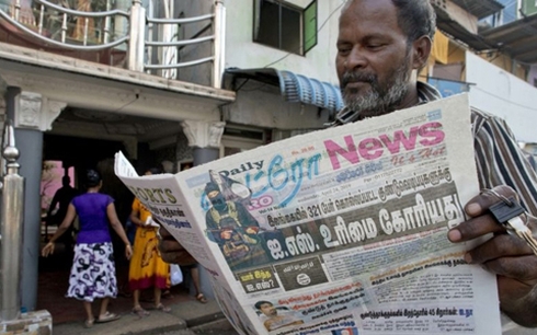 Một người dân Sri Lanka đọc báo ngày 23/4, trang nhất là thông tin IS nhận trách nhiệm vụ đánh bom liên hoàn. Ảnh: AP