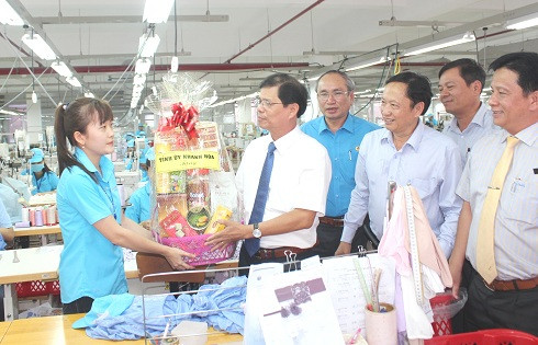 Ông Nguyễn Tấn Tuân tặng quà cho đại diện công nhân Công ty TNHH MTV phát triển trang phục phụ nữ kiểu Pháo Việt Nam.