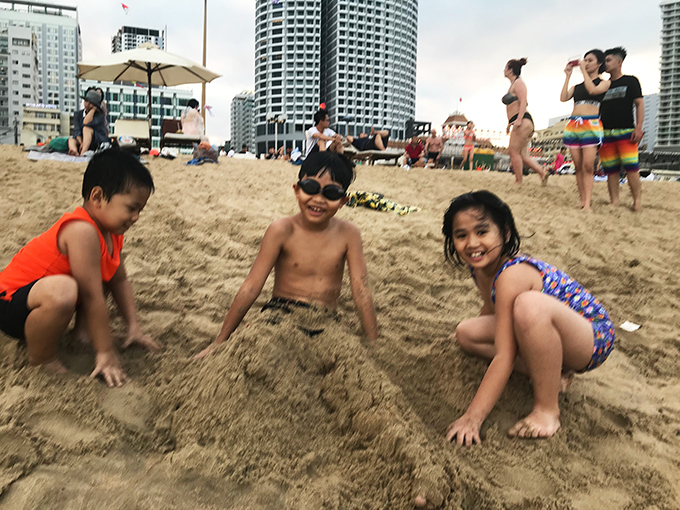 Những em nhỏ chơi đùa với cát.