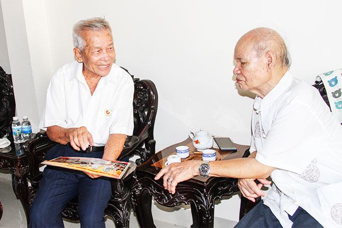 Ông Nguyễn Thanh Mai và ông Hoàng Diệm xem lại  những tấm ảnh về chiến thắng Điện Biên Phủ.