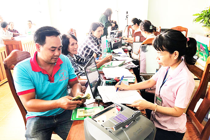 A borrower receiving loan at transaction office of the Bank for Social Policies in Van Ninh District.