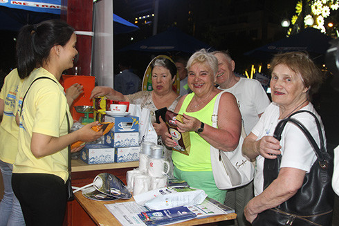 Du khách nước ngoài thích thú với lễ hội và mua cà phê Mê Trang về thưởng thức