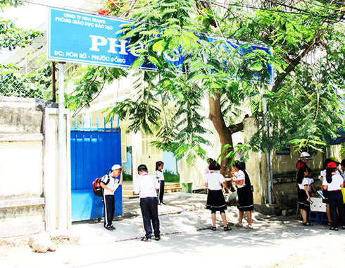 Hiện nay, bảng hiệu Trường Tiểu học Phước Thịnh (xã Phước Đồng, TP. Nha Trang) bị tán cây che phủ, trông không đẹp (ảnh). 