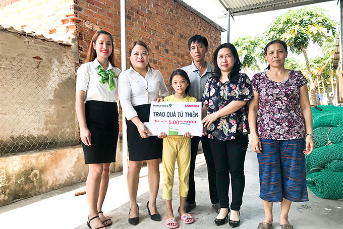 Đại diện Báo Khánh Hòa và Vietcombank Nha Trang trao tiền  ủng hộ cho gia đình hai anh em Long và Thanh. Ảnh: Mã Phương