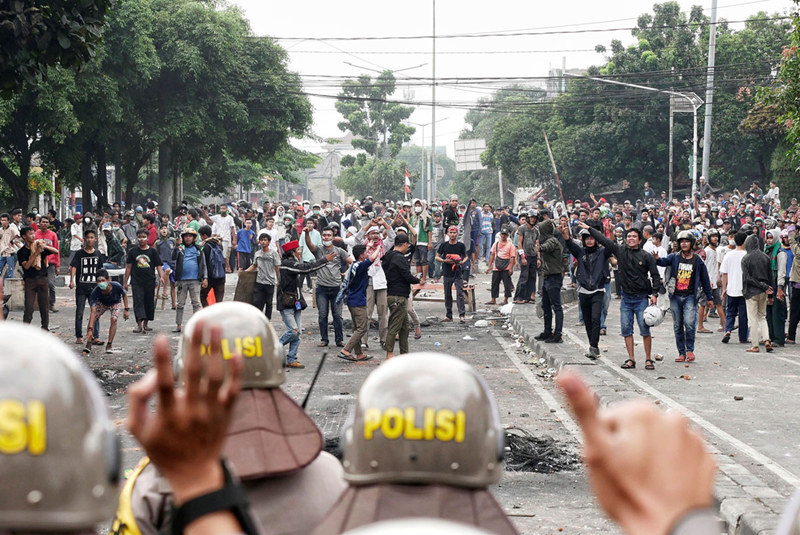 Người biểu tình ném đá vào cảnh sát tại khu chợ Tanah Abang ở Jakarta ngày 22/5. Ảnh: Getty.
