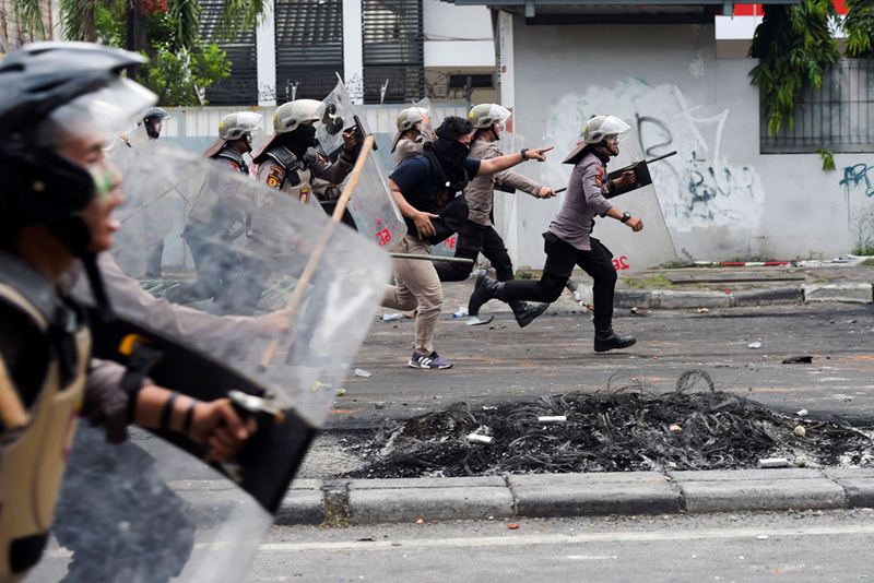 Cảnh sát đang đuổi theo những người biểu tình tại Tanah Abang. Ảnh: Reuters