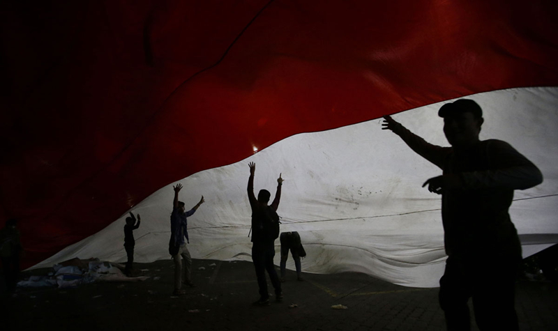 Những người biểu tình ủng hộ ứng cử viên đối lập đi dưới quốc kỳ Indonesia. Ảnh: AP.
