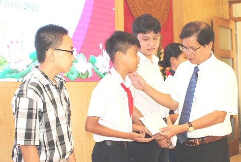 Ông Nguyễn Tấn Tuân trao học bổng cho những học sinh nghèo hiếu học.