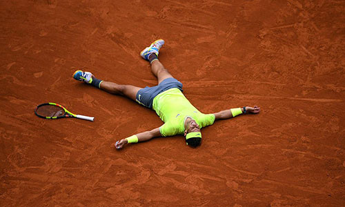 Nadal nằm sân mừng chiến thắng thứ 12 ở Roland Garros. Ảnh: Reuters.