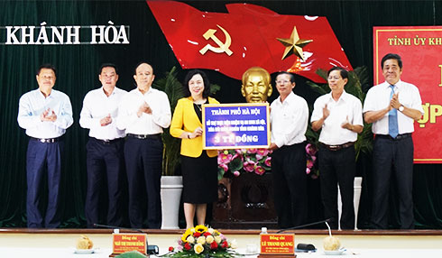 Bà Ngô Thị Thanh Hằng trao tượng trưng số tiền hỗ trợ của TP. Hà Nội.