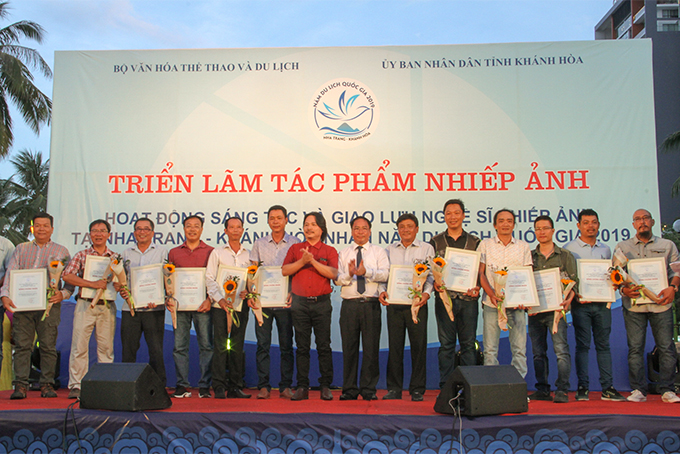Representatives of organization committee offering certificate of participation to art photographers