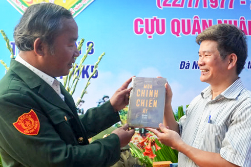 Nhà văn Đoàn Tuấn (bên phải) tặng sách cho đồng đội.